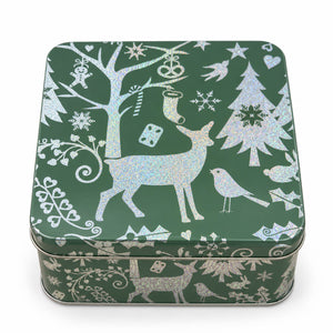 A square green tin box decorated with silver glittery winter illustrations, including a deer, bird, tree, snowflakes, and ornaments, shown on a white background.