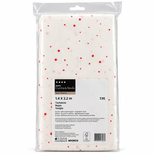A packaged sheet of white toffia nappe with small red star prints, branded Cotta & Toscana by Migros. The sheet is sealed in a clear plastic bag with a product label showing dimensions of 1.