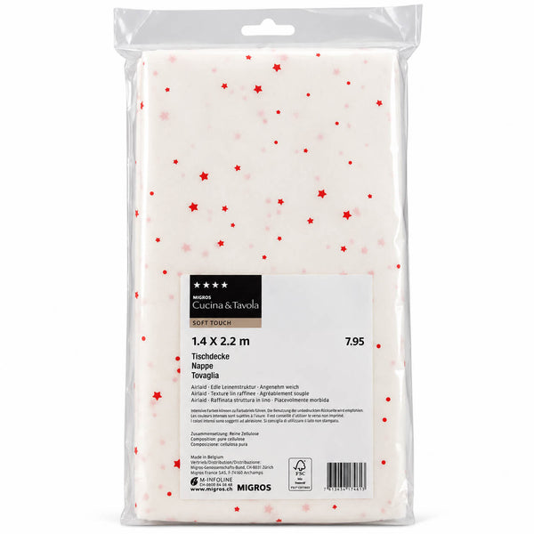 A packaged sheet of white toffia nappe with small red star prints, branded Cotta & Toscana by Migros. The sheet is sealed in a clear plastic bag with a product label showing dimensions of 1.