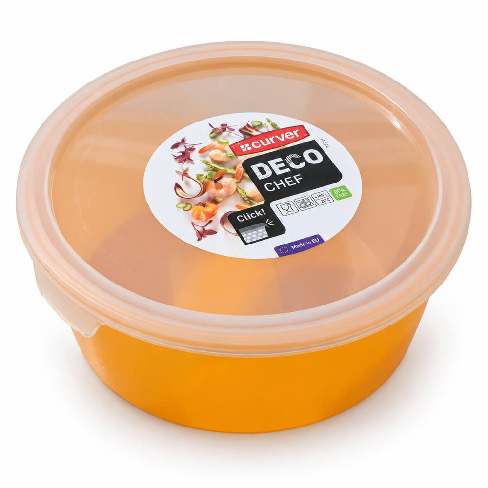 A translucent orange plastic food storage container with a matching translucent lid, shown open and filled with a pasta salad on a wooden countertop in a bright kitchen setting.