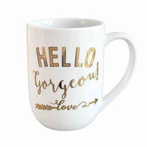 A white ceramic coffee mug with gold foil lettering that reads 'HELLO Gorgeous! love' on a plain white background.