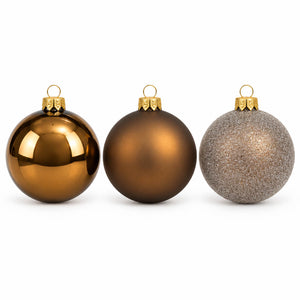 Three Christmas ball ornaments on a white background: one glossy bronze, one matte bronze, and one glittery silver.