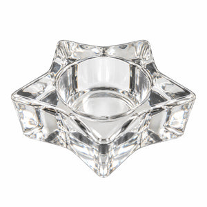 A clear crystal star-shaped candle holder with a central well, photographed on a solid white background.