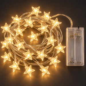 Warm white star-shaped LED fairy string lights coiled on a dark background, shown with a clear battery compartment containing two batteries.