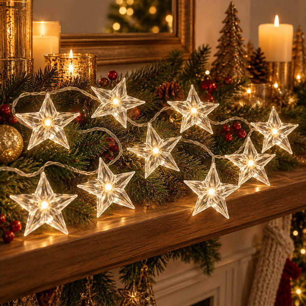 Star-shaped clear glass string lights glowing warmly on a decorated Christmas mantel with green garland, candles, ornaments, and pinecones.