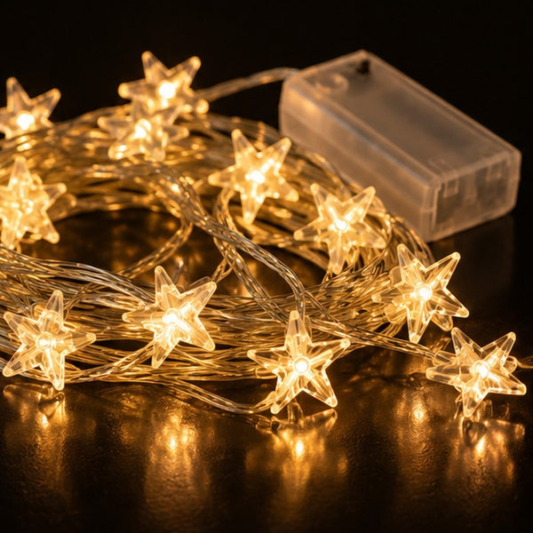 Warm white star-shaped string lights with a clear battery pack, shown on a dark reflective surface.