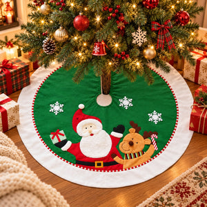 A round green Christmas tree skirt with embroidered Santa Claus, a reindeer, and white snowflakes, displayed under a decorated Christmas tree on a wooden floor with wrapped gifts around it.