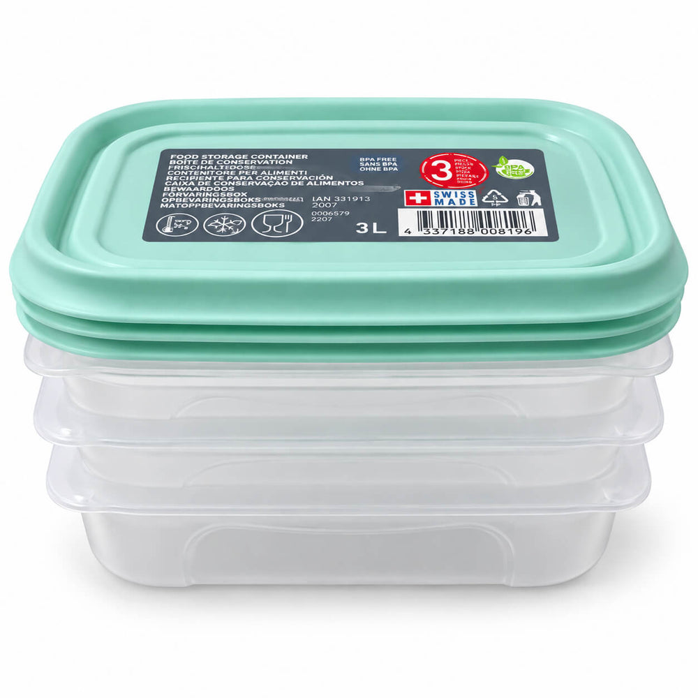 Three clear plastic rectangular food storage containers with light blue silicone lids are arranged on a wooden countertop, with one container open and filled with assorted fruit. A matching lid sits in the foreground.