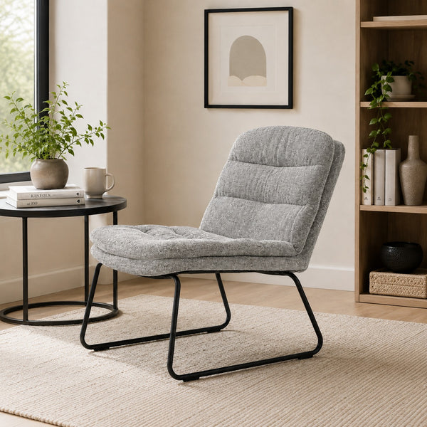 Light grey upholstered lounge chair with a cushioned seat and black metal sled base on a clean white background.