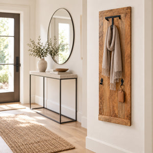 A rustic wooden entryway hook rack mounted on a white wall, holding a beige scarf and keys, shown in a bright, modern hallway with a console table and mirror.