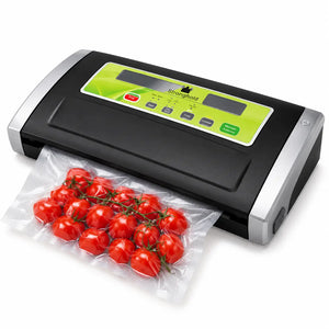 A black and silver Dragonhold vacuum sealer with a green control panel, shown sealing a clear plastic bag of red cherry tomatoes on a white background.