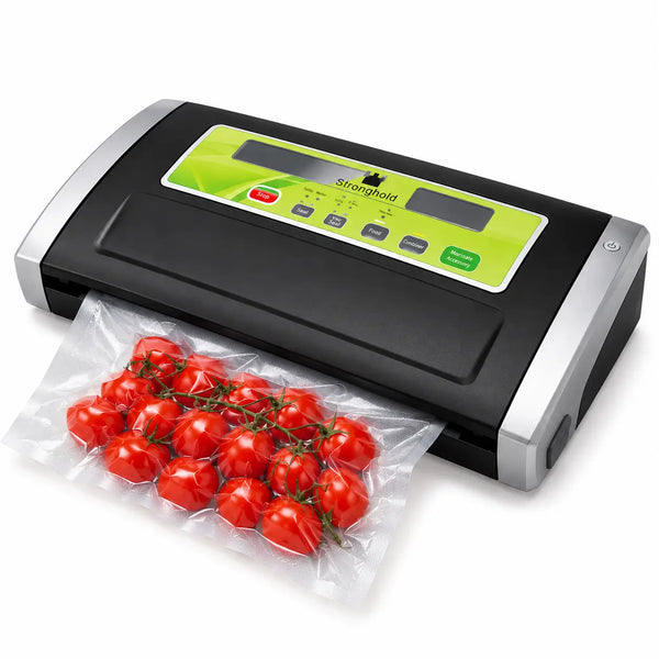 A black and silver Dragonhold vacuum sealer with a green control panel, shown sealing a clear plastic bag of red cherry tomatoes on a white background.