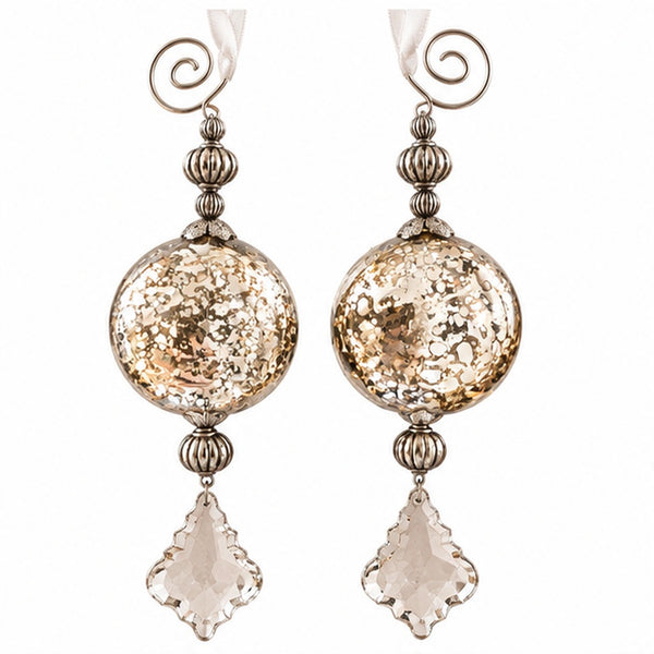 A pair of dangling statement earrings with large textured gold-toned round beads, silver-toned filigree details, spiral ear hooks, and clear faceted clover-shaped drops, shown on a plain white background.