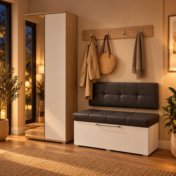 A modern entryway bench with a white storage base and a dark gray tufted cushioned backrest, styled in a warm, contemporary hallway next to a mirrored wardrobe and wall hooks.