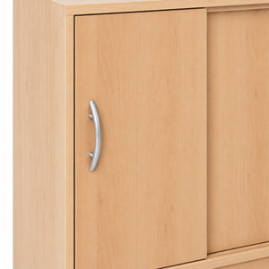 Close-up of a light natural wood cabinet with a curved silver metal handle on a white background.