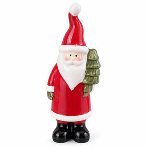 A glossy ceramic Santa Claus figurine holding a small green Christmas tree, set against a plain white background.