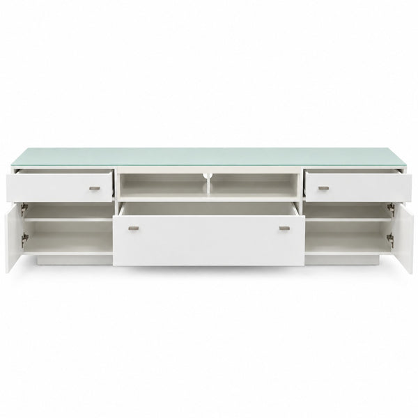 A modern white media console with a light green glass top, featuring multiple drawers, open shelves, and cabinet doors shown in an open position against a white background.