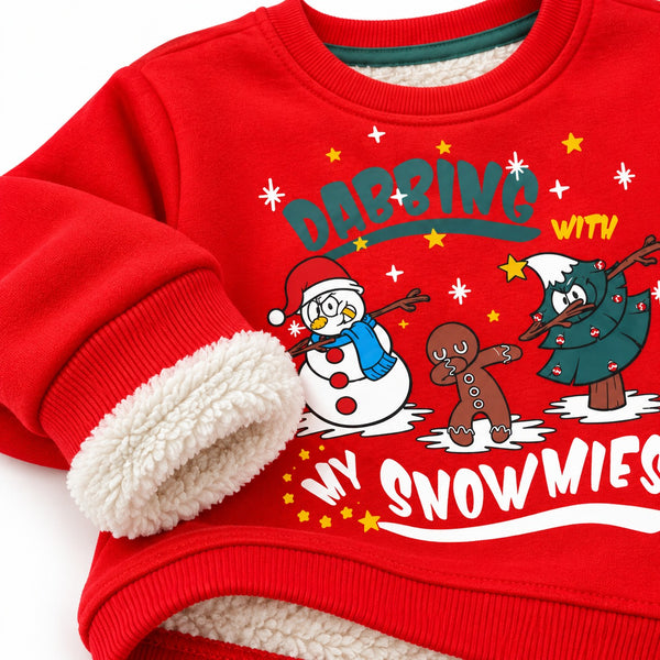 A close-up of a red Christmas sweatshirt with a plush cream sherpa lining and a festive graphic on the front showing a snowman, gingerbread man, and tree dancing with the text 'DANCING WITH MY SNOWMEN'.