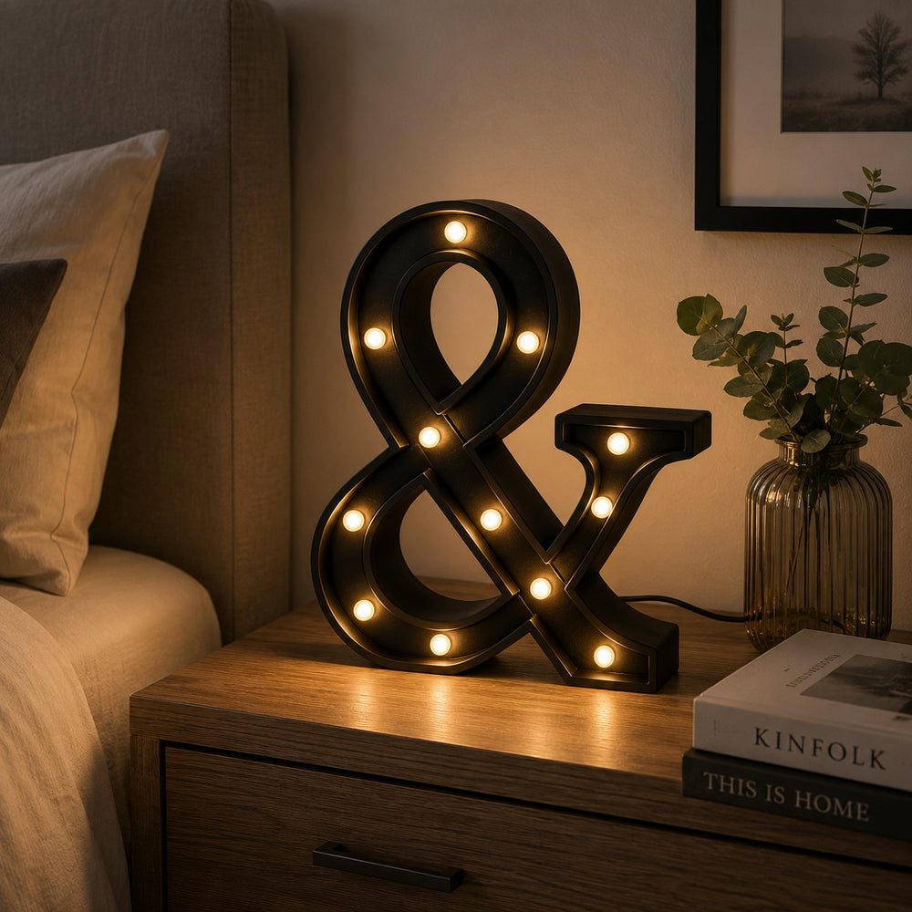 Micasa LORA decorative LED ampersand table lamp on a modern bedside table creating a warm, cozy atmosphere.