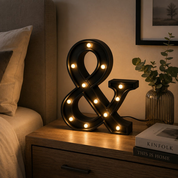 Micasa LORA decorative LED ampersand table lamp on a modern bedside table creating a warm, cozy atmosphere.