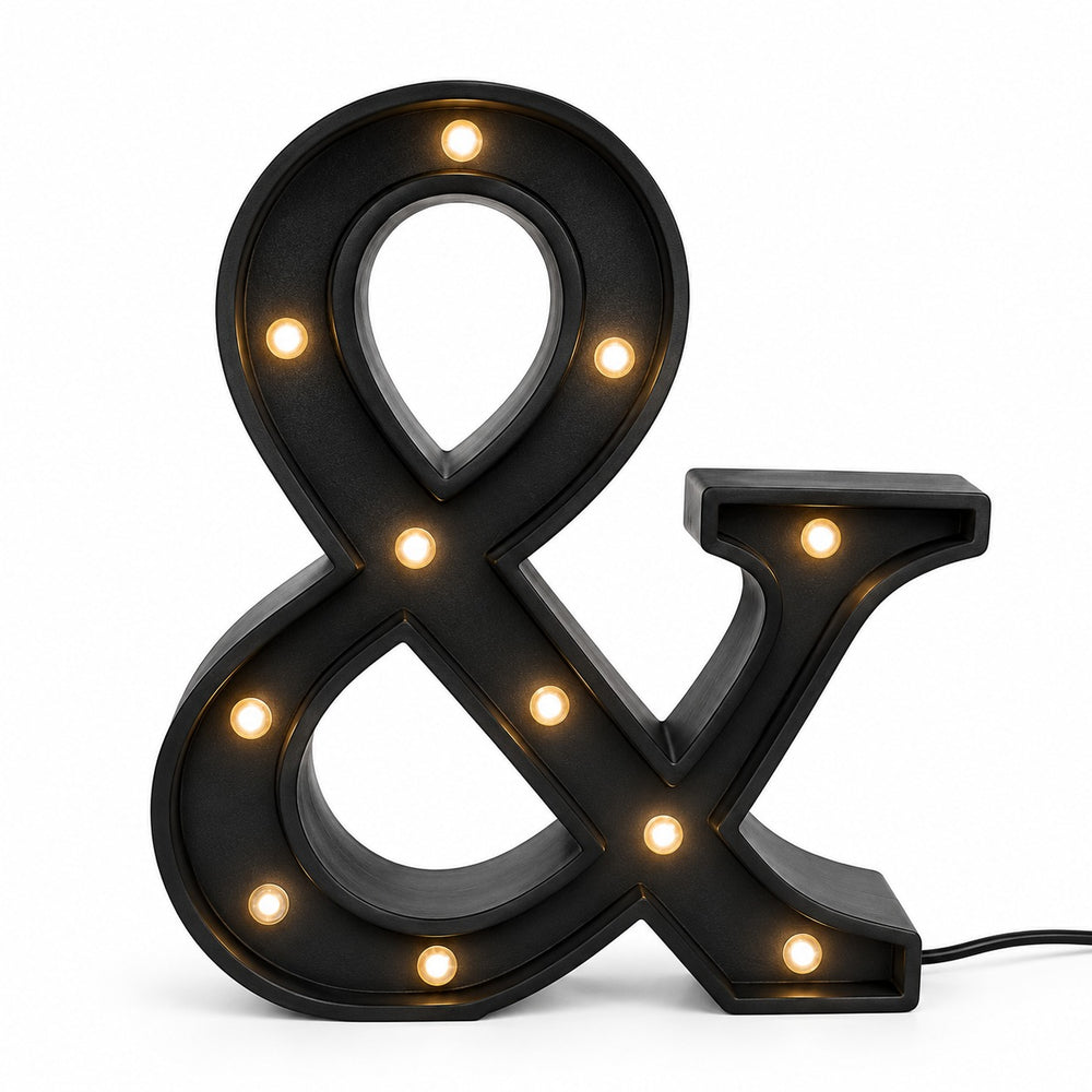 Micasa LORA decorative LED ampersand table lamp on a modern bedside table creating a warm, cozy atmosphere.