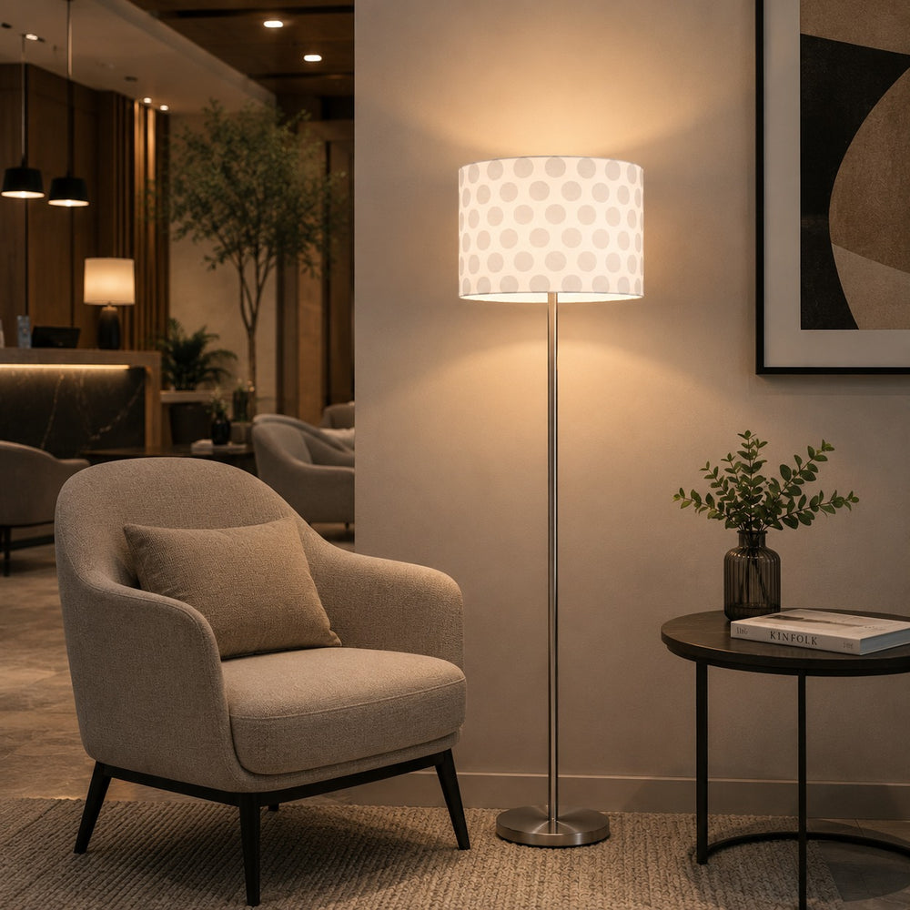 Micasa modern floor lamp with brushed nickel finish and white patterned fabric shade illuminating a contemporary hotel lounge with elegant ambient lighting.
