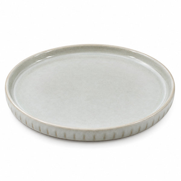 A round ceramic serving platter with a fluted rim, featuring a matte light gray-green glaze on a white background.