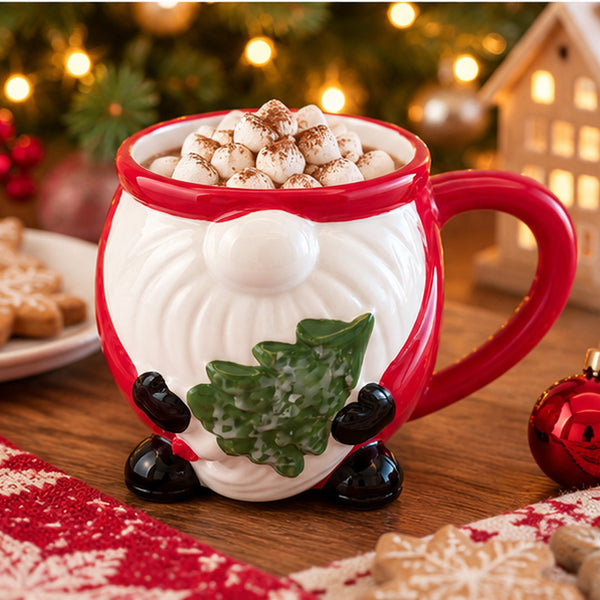 A festive ceramic mug shaped like a gnome, filled with a hot drink topped with marshmallows, set on a wooden table with Christmas decorations and blurred holiday lights in the background.