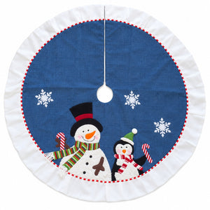 A round Christmas tree skirt with a white ruffled border, featuring a blue center printed with snowflakes and two snowmen, one large and one small, holding candy canes.