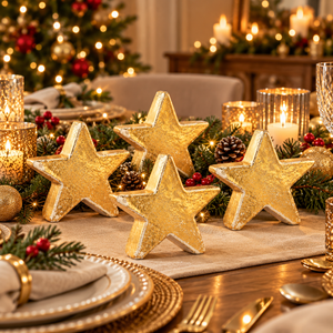 Four gold ceramic star decorations displayed on a cozy Christmas dining table