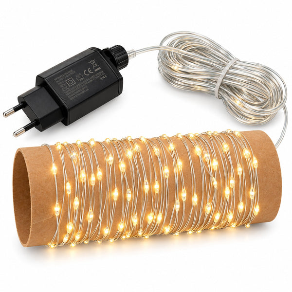 Warm white LED fairy string lights coiled on a brown cardboard tube, with a black power adapter and clear wire shown on a white background.