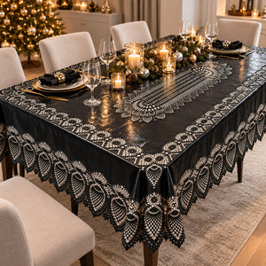 A black tablecloth with an intricate white lace-like border and central floral pattern, draped over a dining table set for four in a decorated holiday dining room.