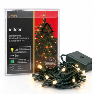 Noél indoor Christmas string lights in a clear plastic package, shown with a coiled bundle of warm white LED lights and a black power adapter on a white background.