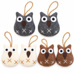 Six felt owl ornaments in dark gray, cream, and brown, each with white embroidered eyes, a brown felt beak, white stitched details, and a jute hanging loop, arranged on a white background.