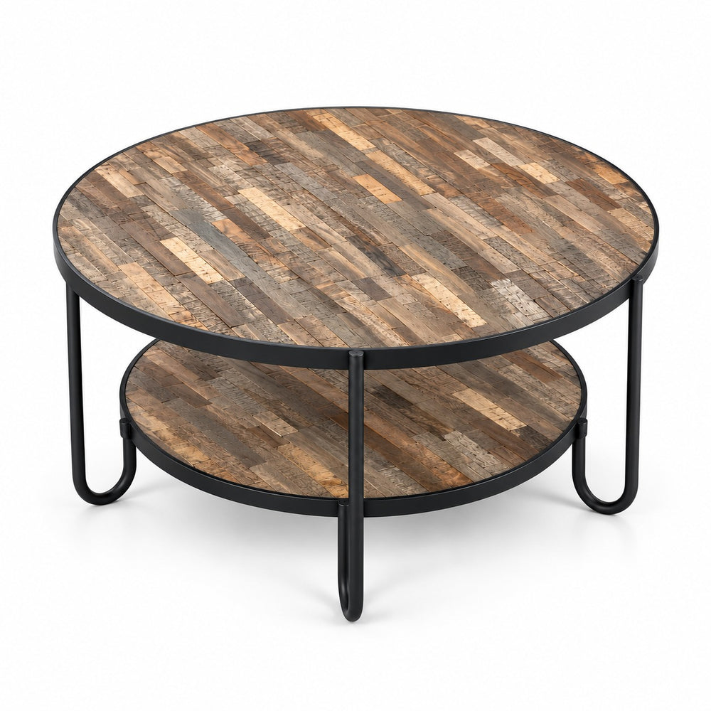 Round rustic coffee table with a two-tier wooden shelf and black metal legs, styled in a cozy living room next to a brown leather sofa.