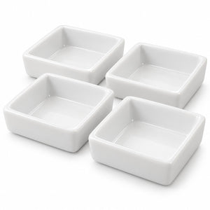 Four white square ceramic bowls arranged in a 2x2 grid on a clean white background.