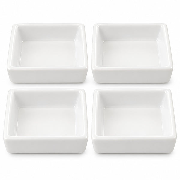 Four white square ceramic dishes arranged in a 2x2 grid on a plain white background.