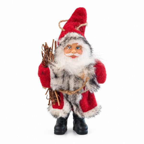 A festive Santa Claus figurine with a red hat and coat, white beard, gray and black fur-like body, and black boots, holding a bundle of twigs against a plain white background.