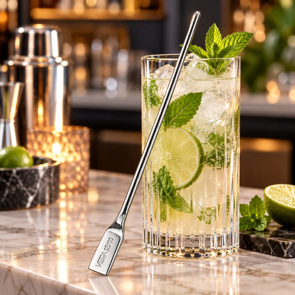 VEGA stainless steel cocktail stirrer beside a tall cocktail glass with lime and mint