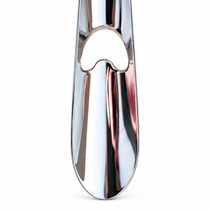 A close-up of a polished chrome metal object, likely a faucet handle or decorative hardware, featuring a reflective silver finish with a heart-shaped cutout detail, set against a plain white background.