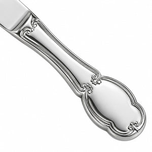 A close-up of a polished silver-toned metal utensil handle with an ornate decorative looped end, shown on a plain white background.
