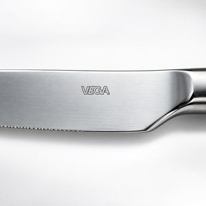Close-up of a stainless steel knife blade with the VEGA brand name engraved on the side, set against a clean white background.
