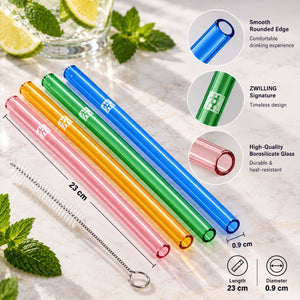 Four translucent drinking straws in pink, orange, green, and blue, shown with a white straw cleaning brush on a marble surface. The image includes callout graphics showing dimensions (23 cm length, 0.